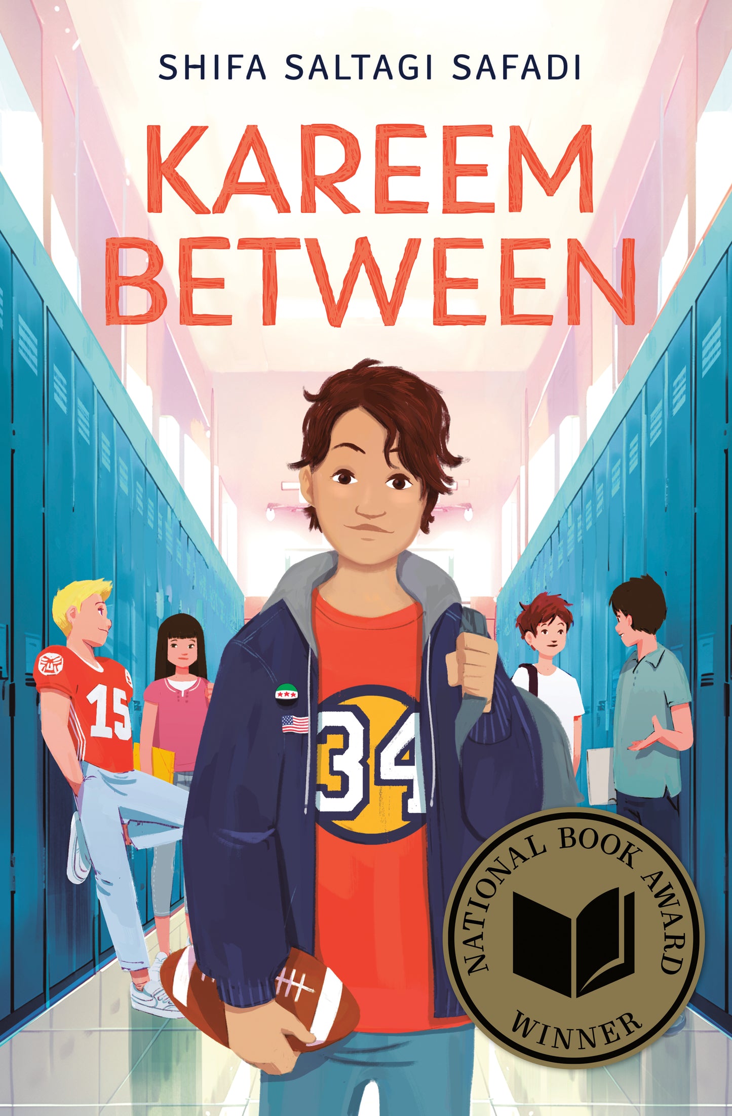 Book cover of 'Kareem Between' with a boy holding a football in a school hallway, featuring the National Book Award winner badge.